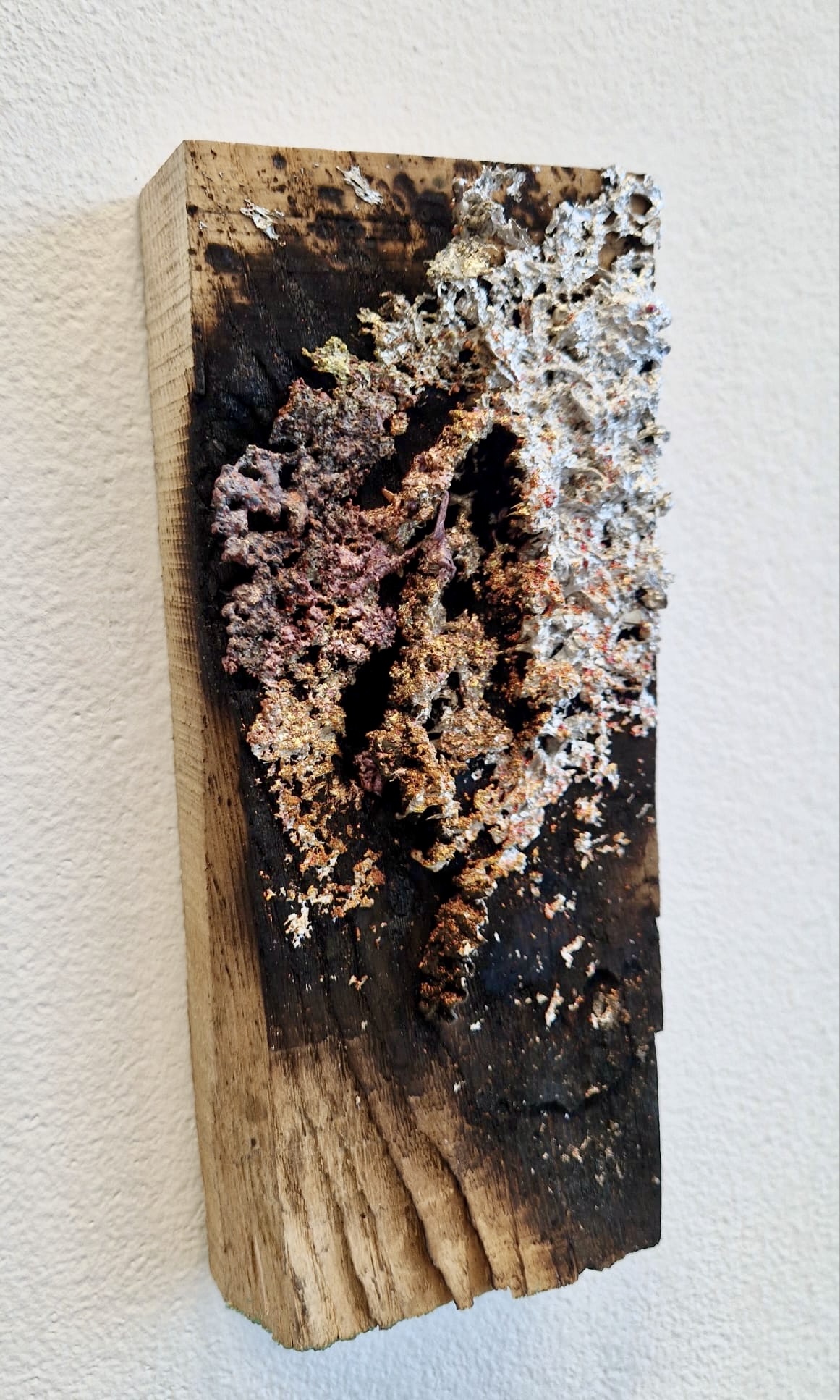 Detail of sprayed metal deposit on wood