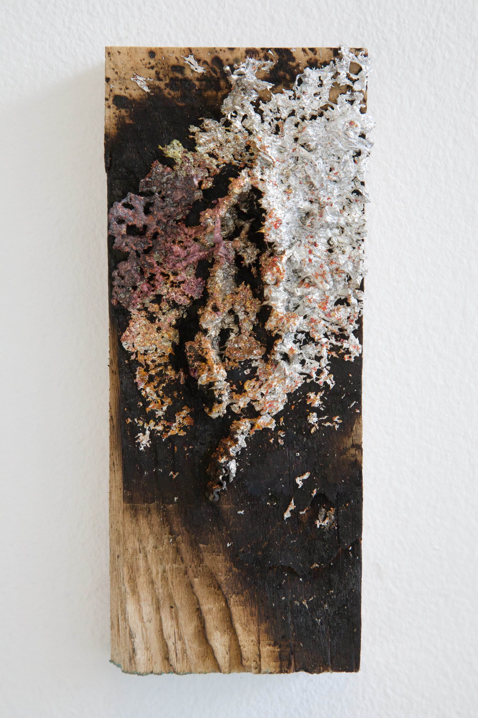 Small charred wood panel with sprayed aluminium, steel and copper-toned metal deposits