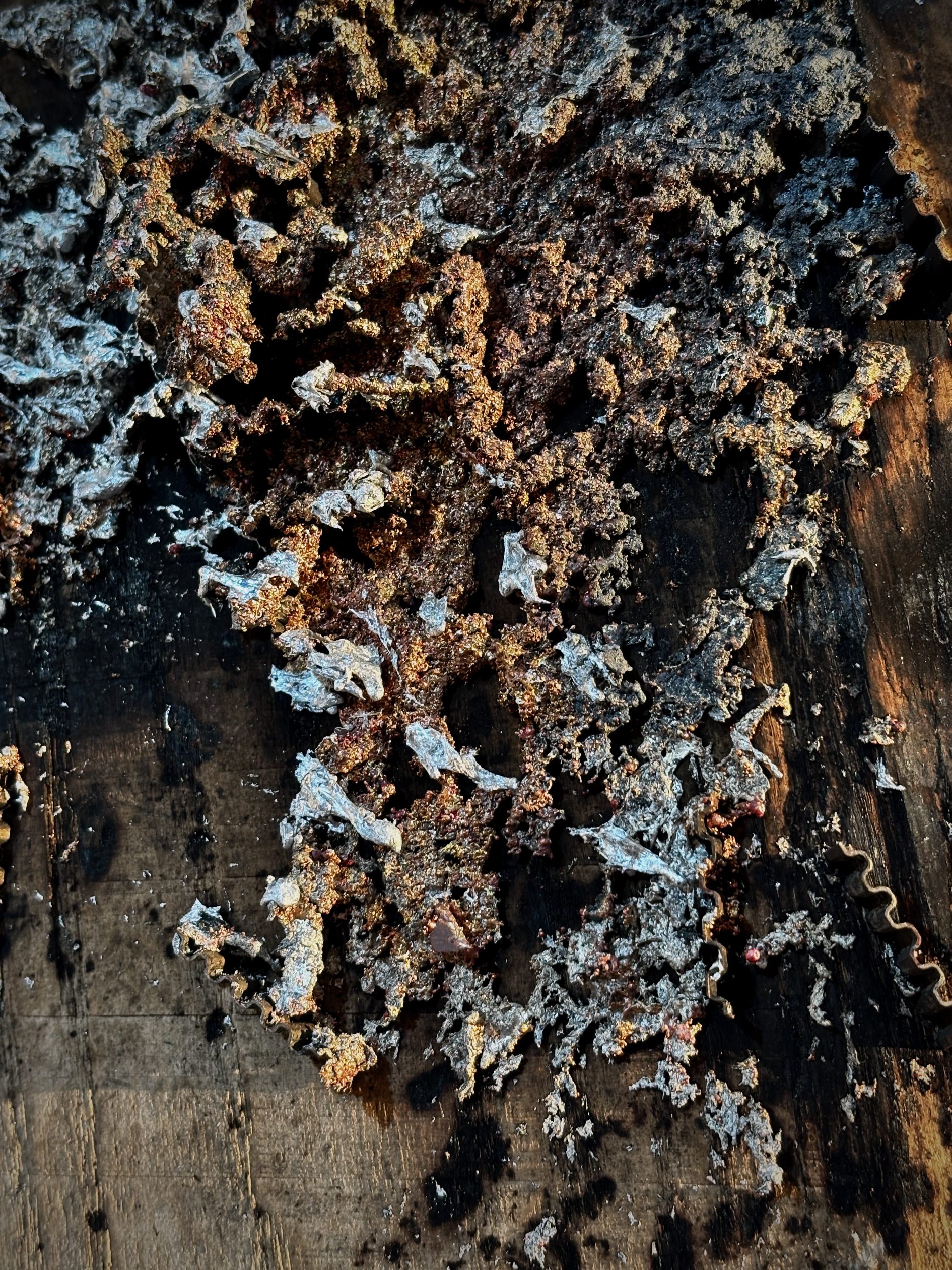Detail of sprayed metal deposit on wood