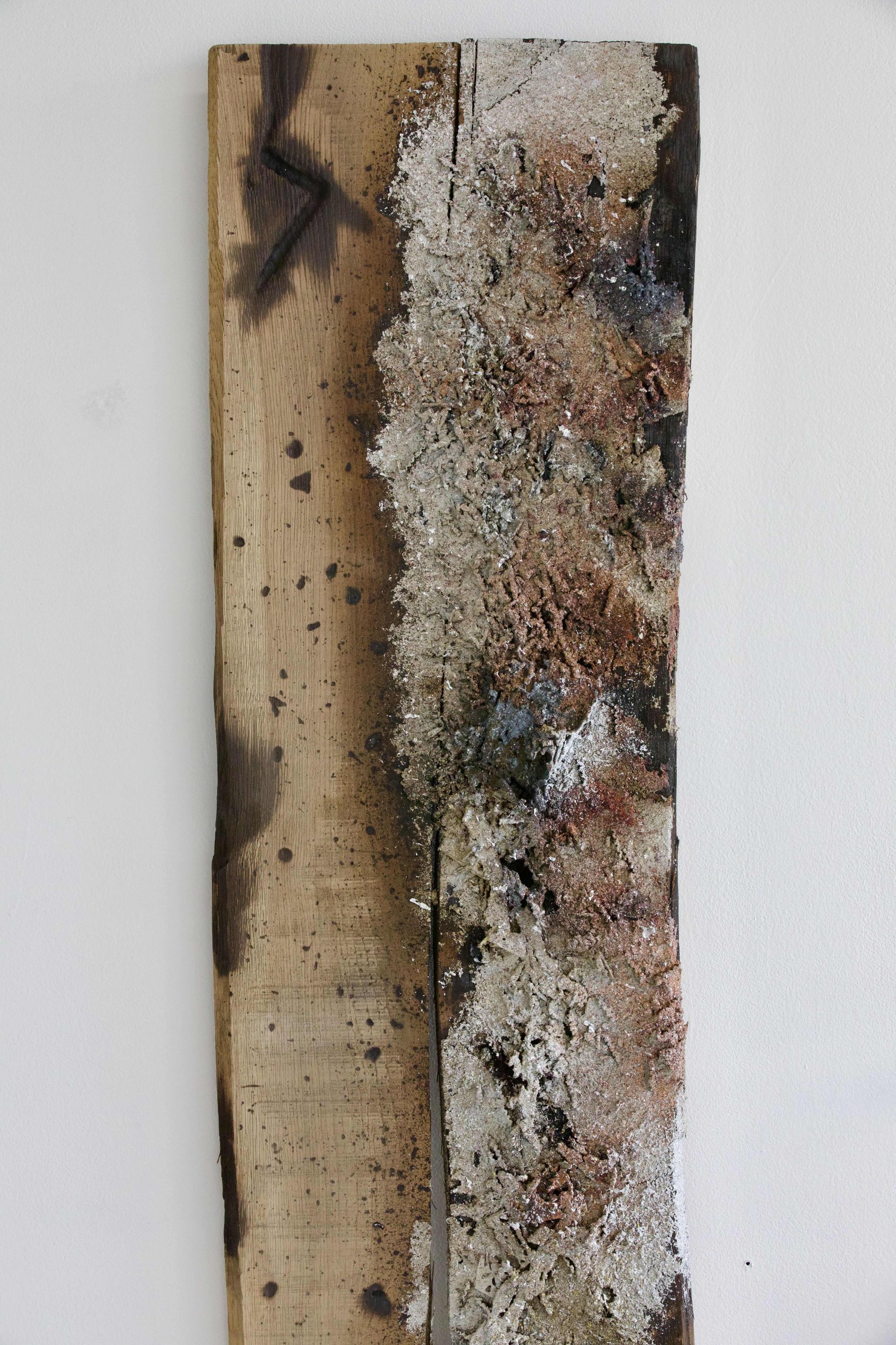 Detail of scorched oak grain and metal residue in Sprawl
