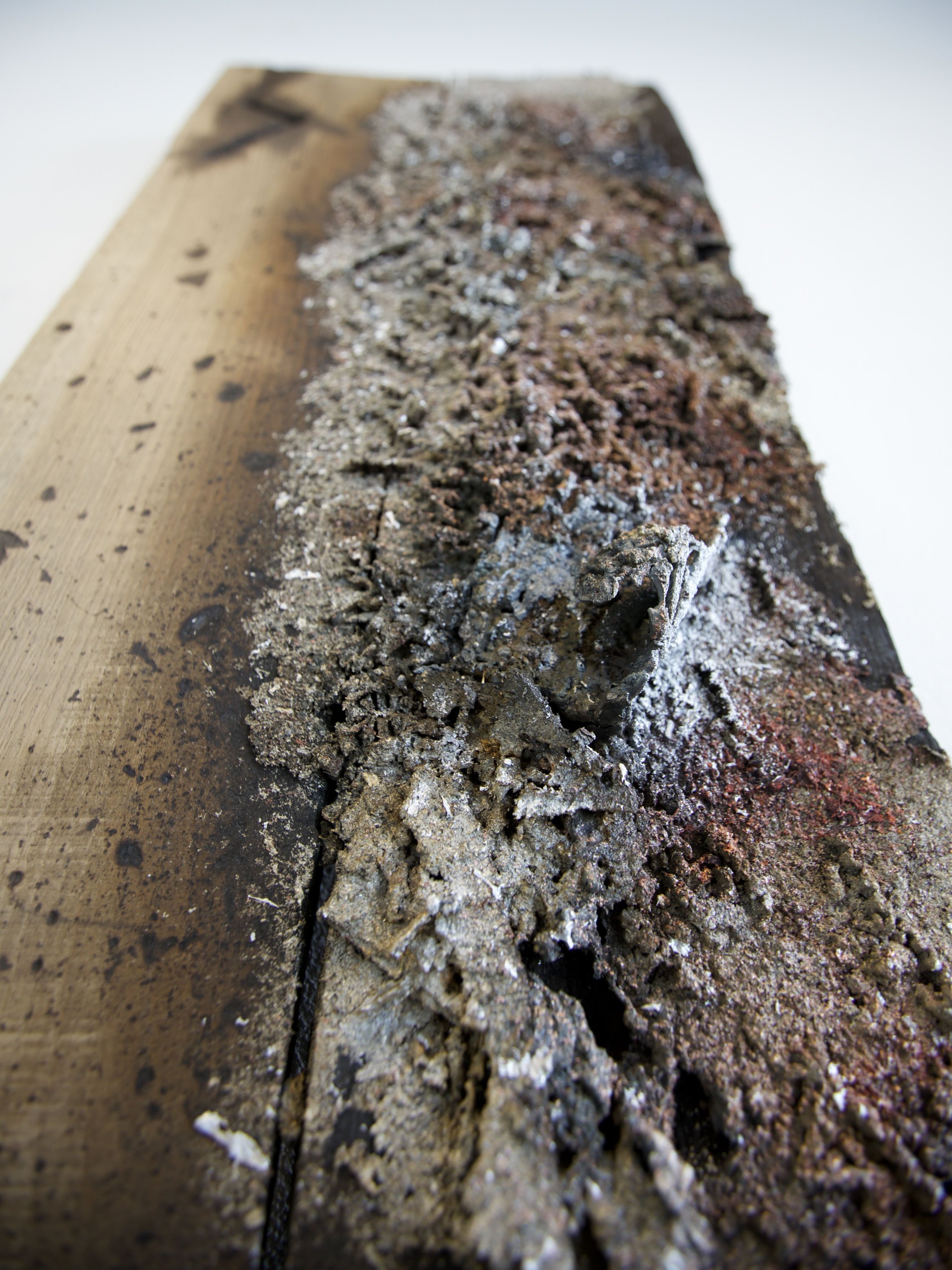 Detail of scorched oak grain and metal residue in Sprawl