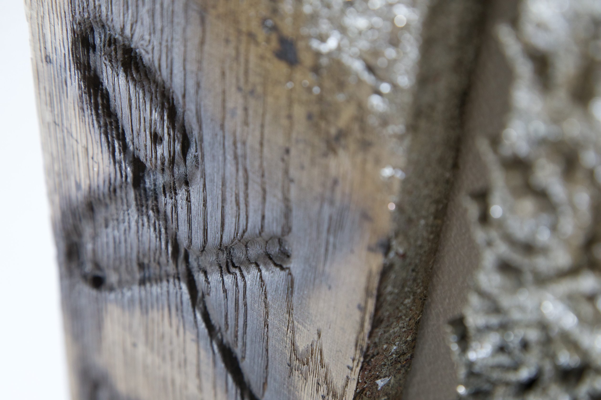 Detail of scorched oak grain and metal residue in Sprawl