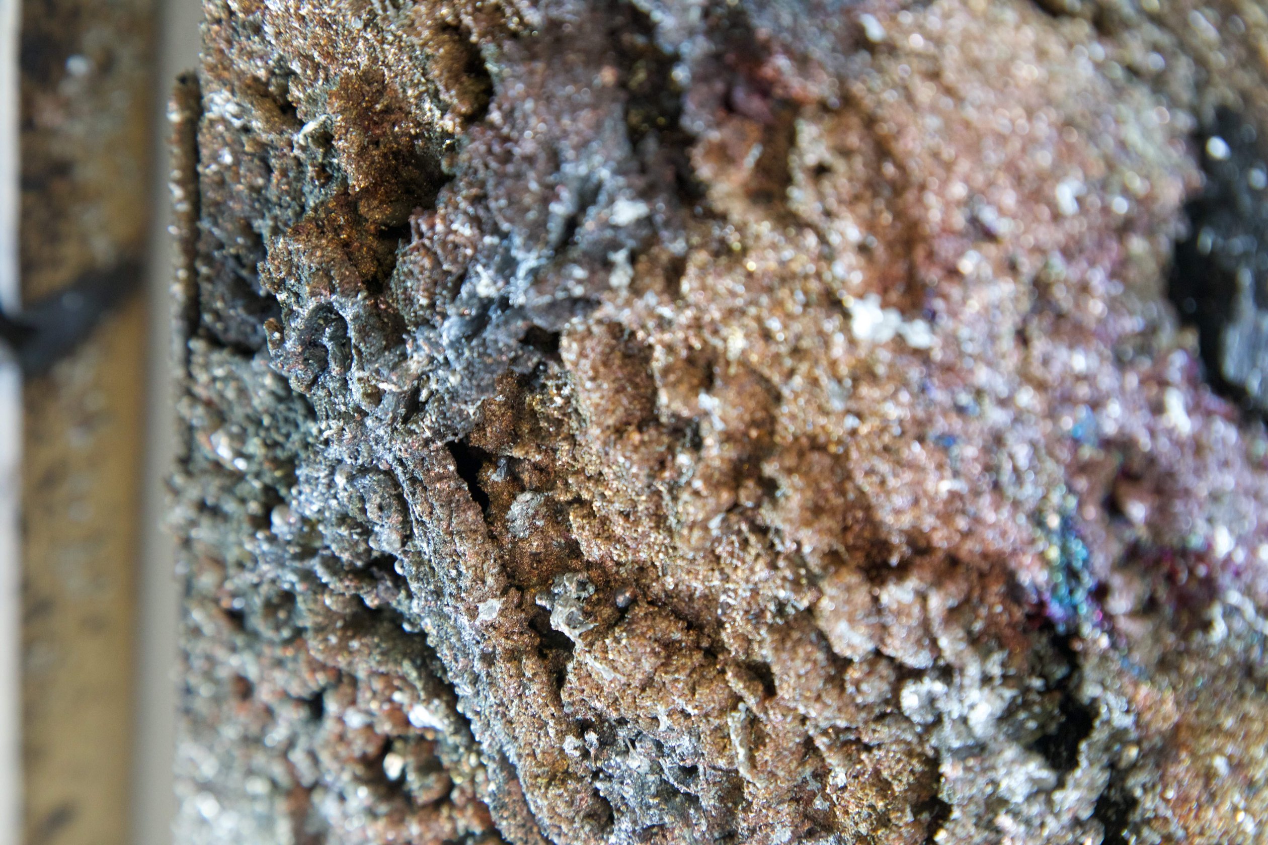Detail of scorched oak grain and metal residue in Sprawl