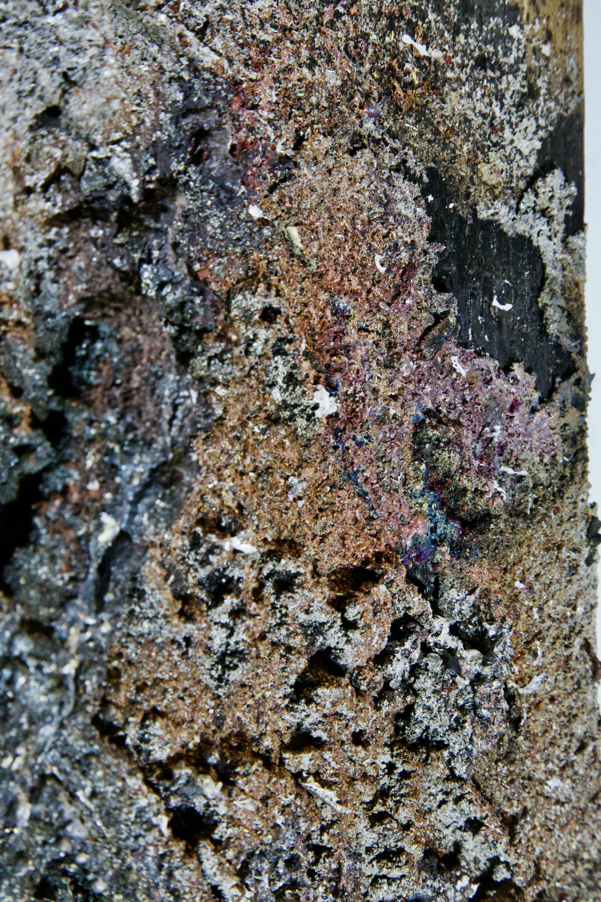 Detail of scorched oak grain and metal residue in Sprawl