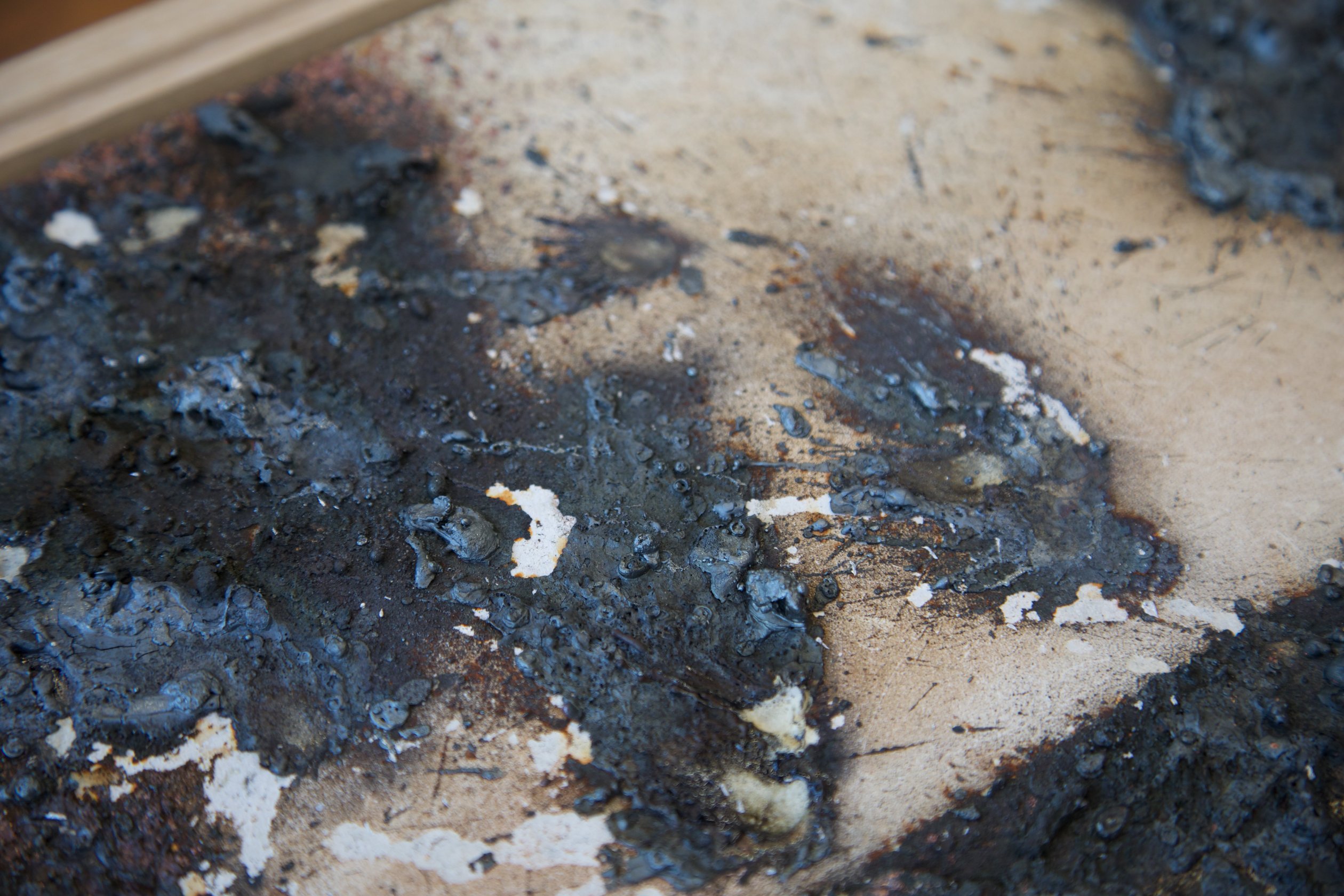 Detail of sprayed metal deposits and cracked mineral tile surface in Dry river